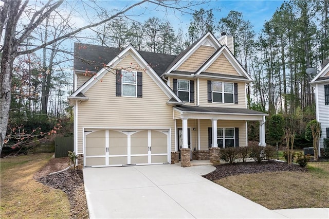 craftsman house featuring an attached garage, covered porch, driveway, and a chimney