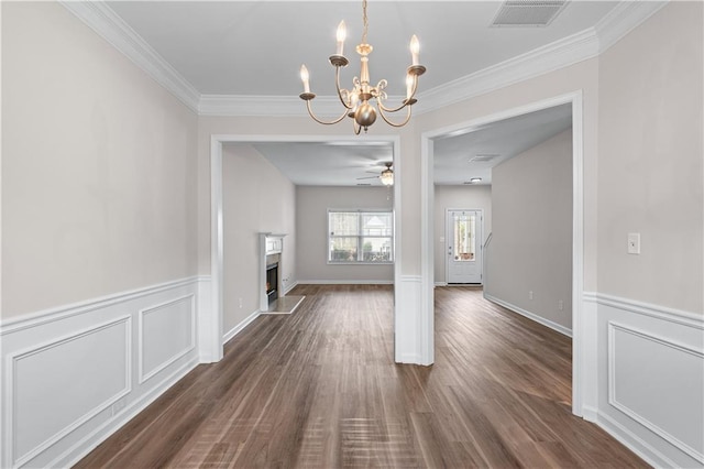 1558 Autumn Wood Trl, Sugar Hill, GA 30518 - unfurnished dining area with a warm lit fireplace, visible vents, crown molding, and wainscoting