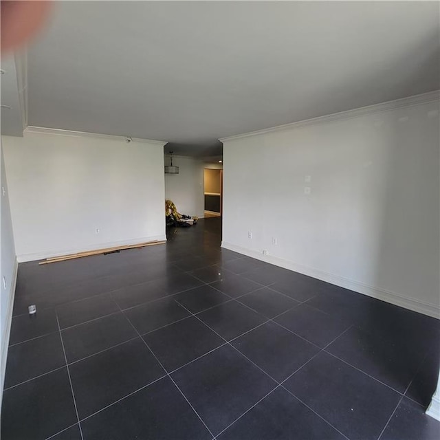 unfurnished living room featuring crown molding and dark tile patterned floors