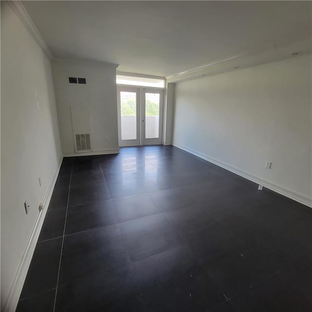 tiled empty room with ornamental molding and french doors