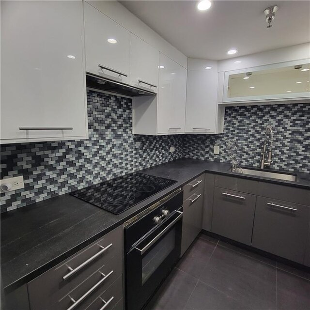 kitchen featuring black appliances, tasteful backsplash, sink, and white cabinets