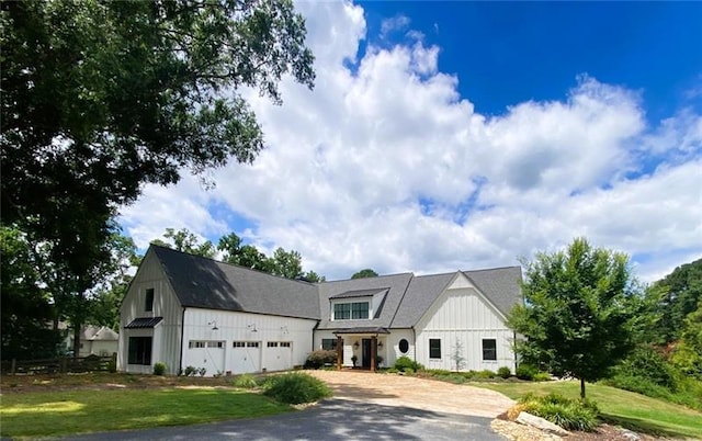 modern farmhouse featuring a garage and a front lawn