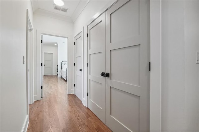 corridor with ornamental molding and wood-type flooring