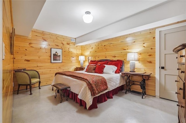 bedroom featuring concrete floors and wood walls