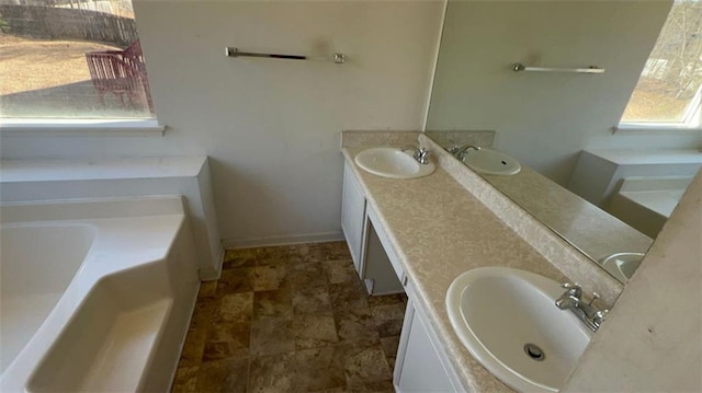 bathroom with a tub to relax in and vanity