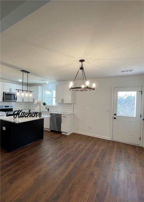 kitchen featuring visible vents, dark wood finished floors, light countertops, appliances with stainless steel finishes, and tasteful backsplash