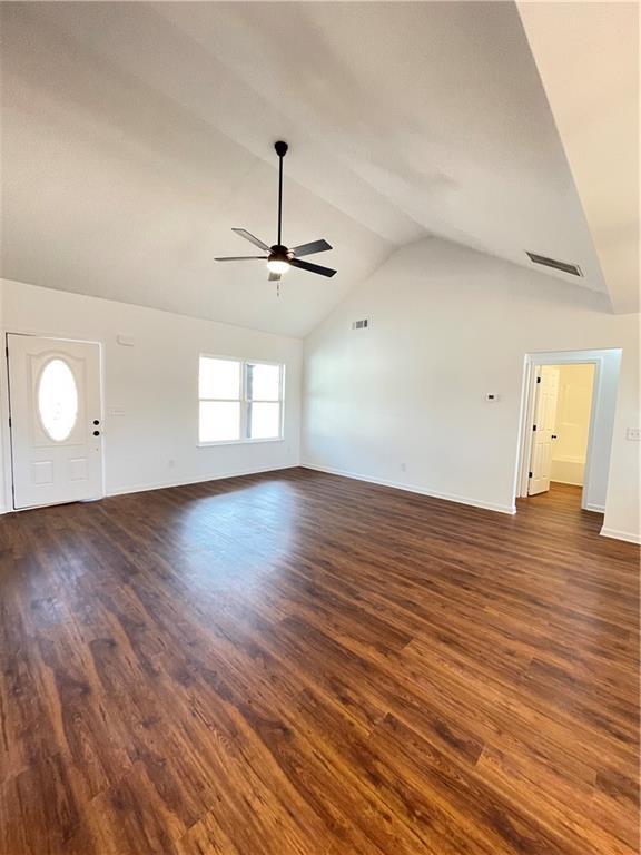 unfurnished living room with lofted ceiling, dark wood-style flooring, and ceiling fan