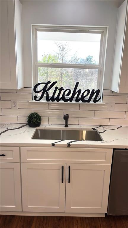 kitchen with white cabinetry, a wealth of natural light, and a sink