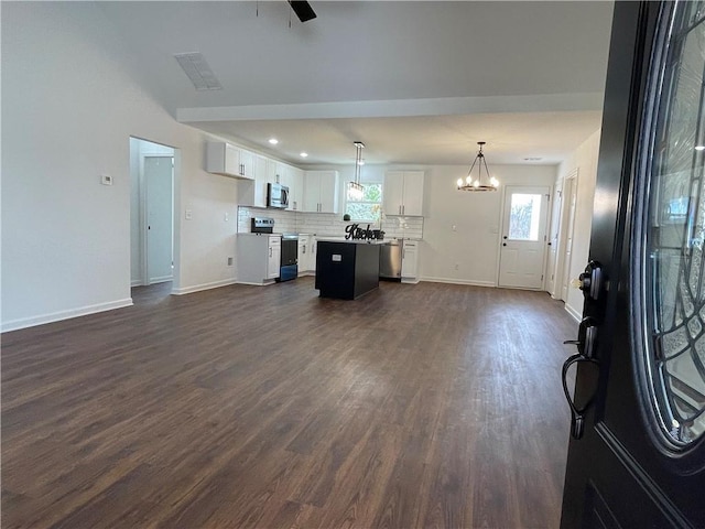 unfurnished living room featuring dark wood finished floors, visible vents, ceiling fan with notable chandelier, and baseboards