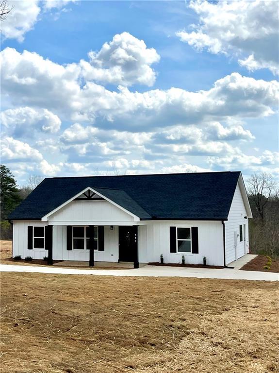 modern inspired farmhouse featuring roof with shingles and covered porch