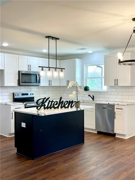 kitchen featuring backsplash, light countertops, dark wood-style floors, white cabinets, and stainless steel appliances