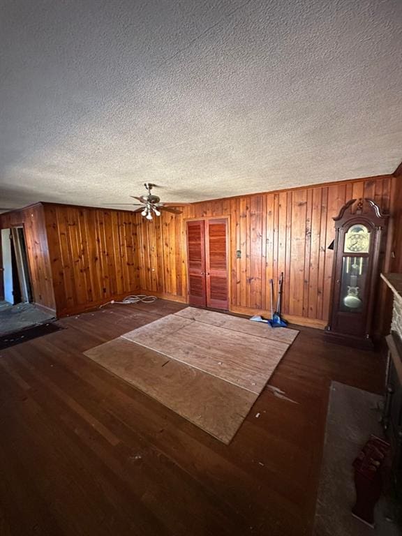 interior space featuring ceiling fan, a textured ceiling, a fireplace, and dark hardwood / wood-style flooring