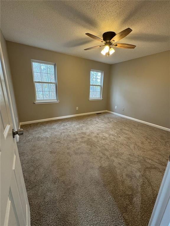 carpeted empty room with ceiling fan and a textured ceiling