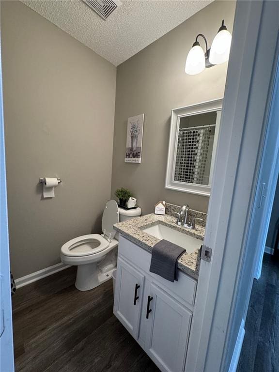 bathroom featuring hardwood / wood-style floors, vanity, and a textured ceiling