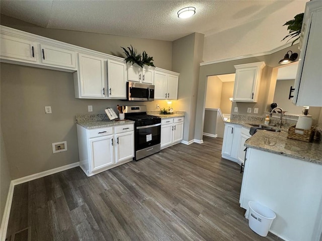 kitchen with a textured ceiling, stainless steel appliances, white cabinetry, and sink