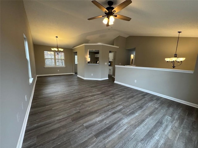 unfurnished living room with ceiling fan with notable chandelier, dark wood-type flooring, and lofted ceiling