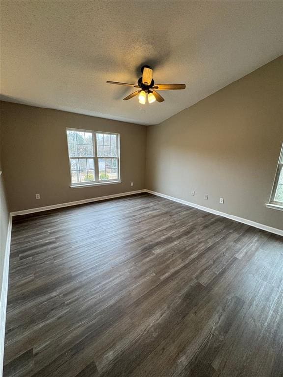 unfurnished room featuring a textured ceiling, dark hardwood / wood-style floors, ceiling fan, and a healthy amount of sunlight