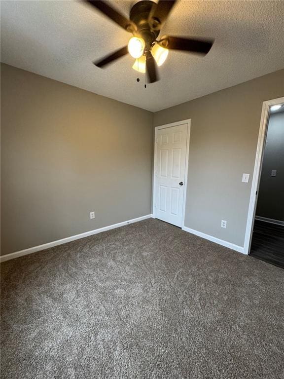 unfurnished bedroom with ceiling fan, dark carpet, and a textured ceiling