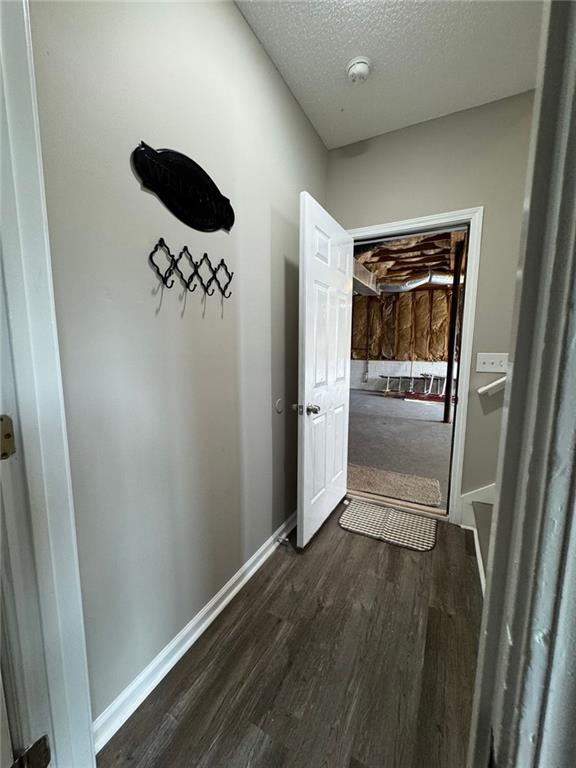 hallway featuring a textured ceiling and dark hardwood / wood-style floors