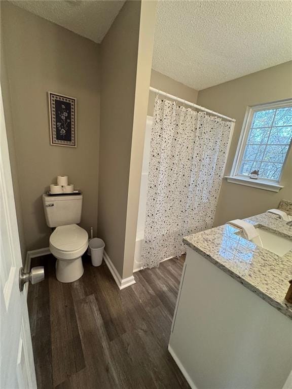 bathroom featuring hardwood / wood-style floors, vanity, a textured ceiling, and toilet