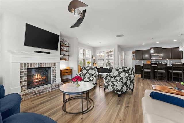 6021 Harbour Mist Dr, Flowery Branch, GA 30542 - living area with a ceiling fan, light wood-style floors, recessed lighting, and a brick fireplace