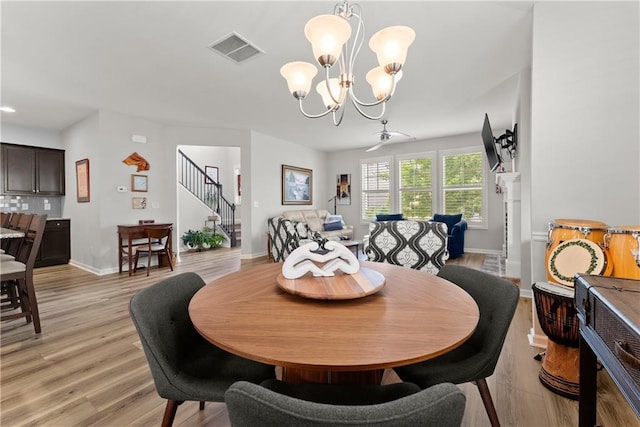 6021 Harbour Mist Dr, Flowery Branch, GA 30542 - dining space featuring stairway, a chandelier, and light wood-style flooring