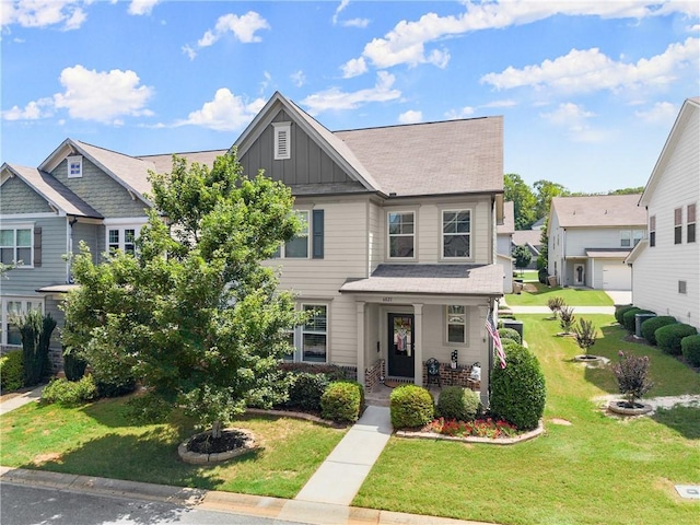 6021 Harbour Mist Dr, Flowery Branch, GA 30542 - view of front of home with board and batten siding, a front lawn, and covered porch