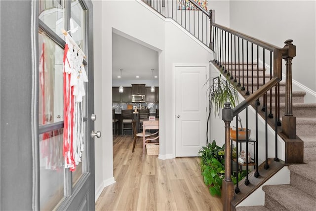 6021 Harbour Mist Dr, Flowery Branch, GA 30542 - foyer entrance featuring light wood-type flooring, stairs, and a towering ceiling