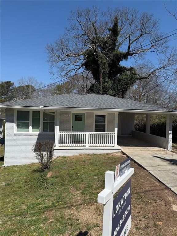 view of front of home with a carport, a porch, brick siding, and driveway