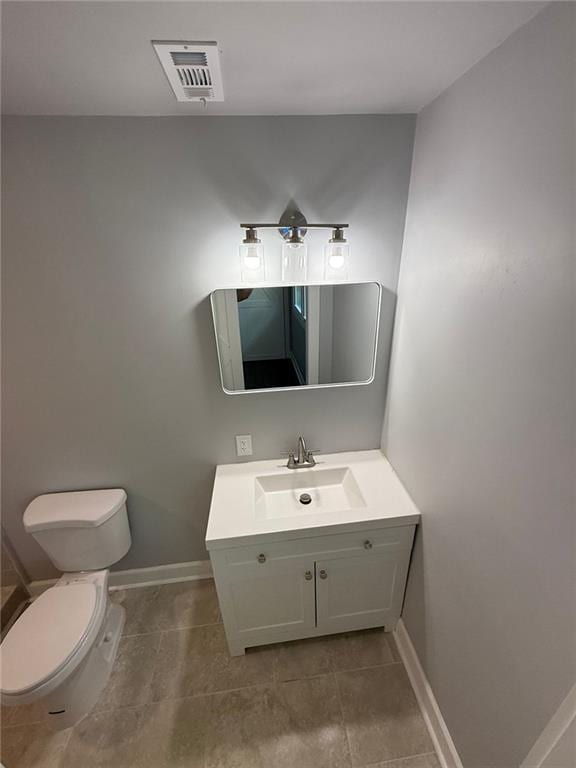 bathroom with vanity, toilet, baseboards, and visible vents