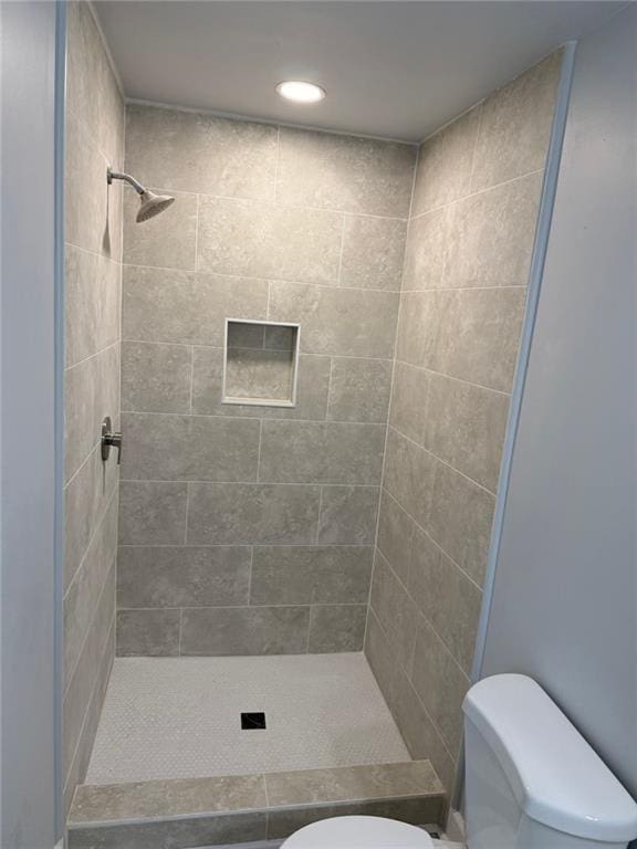 bathroom featuring toilet and a stall shower