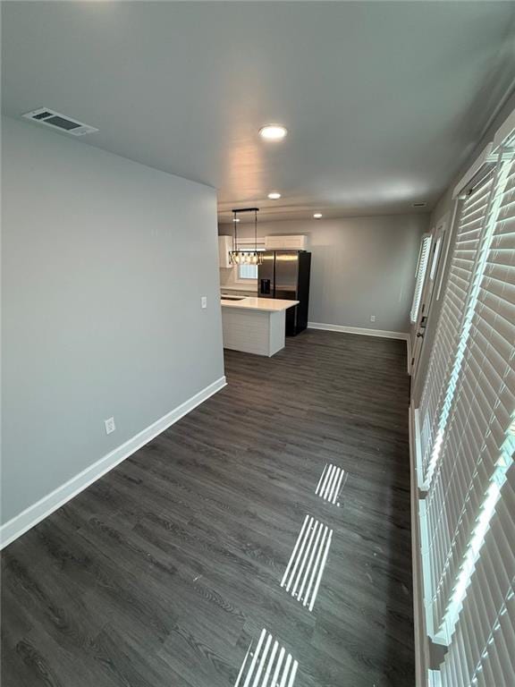 unfurnished living room featuring recessed lighting, baseboards, visible vents, and dark wood-style flooring