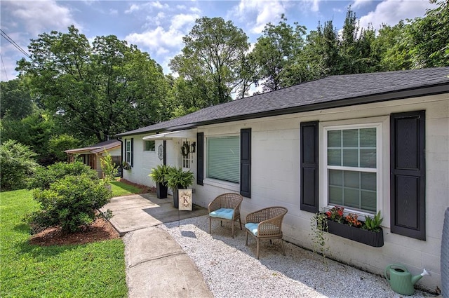 214 Iron St NW, Rome, GA 30165 - view of front of home featuring concrete block siding, a patio area, and a shingled roof