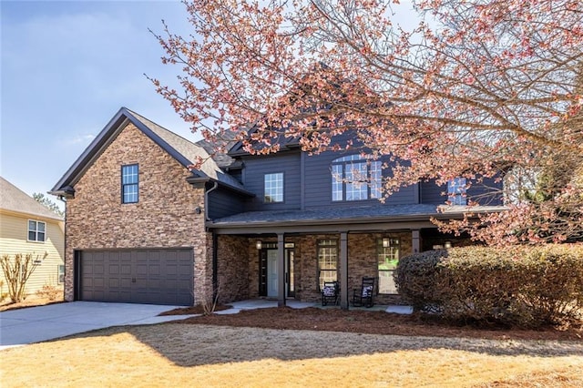 traditional-style home featuring driveway, stone siding, and a garage