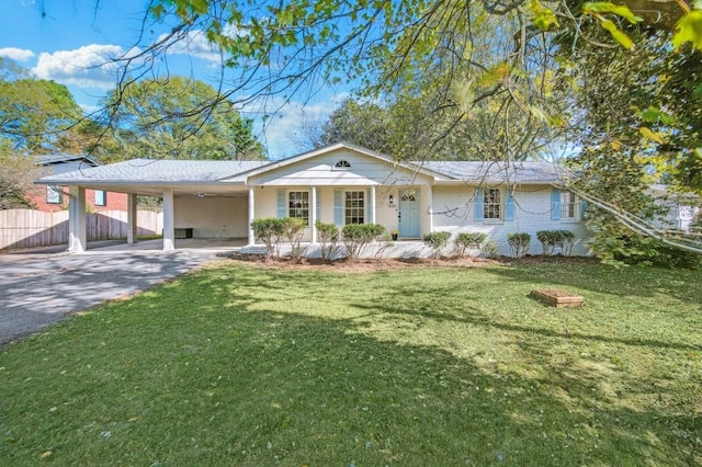 ranch-style house with an attached carport, brick siding, fence, driveway, and a front yard