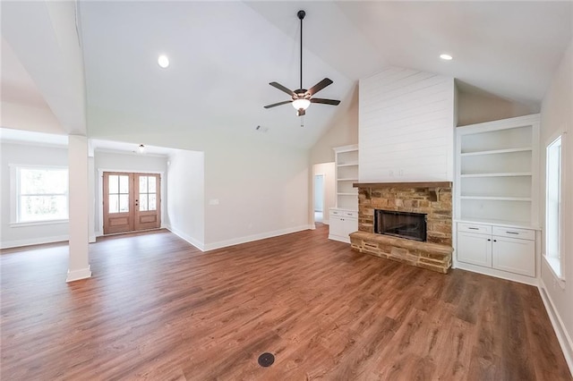 96 Lexie Ct, Rockmart, GA 30153 - unfurnished living room featuring vaulted ceiling, a ceiling fan, a stone fireplace, wood finished floors, and built in features
