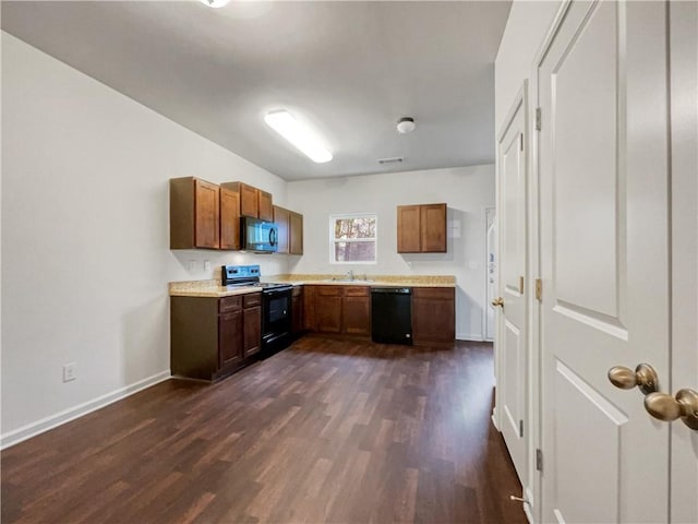 kitchen with black appliances and dark hardwood / wood-style flooring