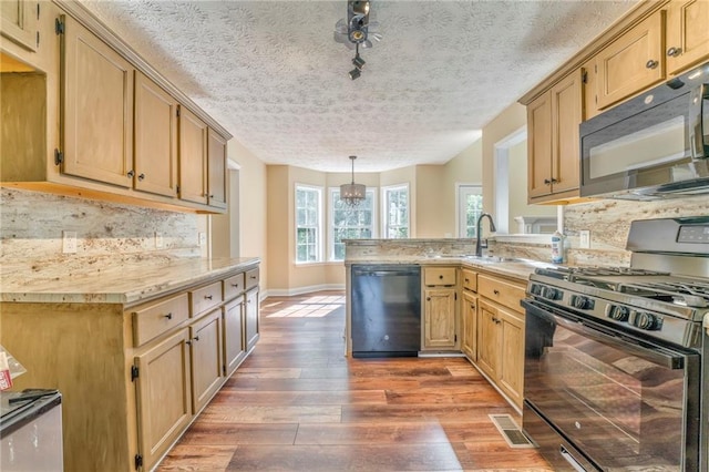 kitchen with dark hardwood / wood-style floors, decorative backsplash, hanging light fixtures, black appliances, and a textured ceiling