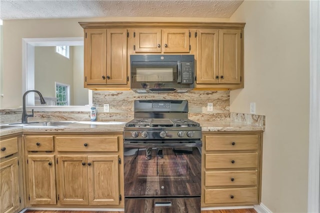 kitchen with light hardwood / wood-style flooring, black appliances, sink, and a textured ceiling