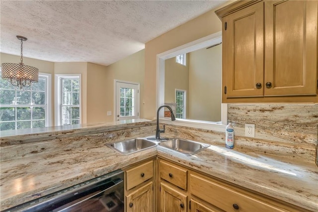 kitchen featuring pendant lighting, a notable chandelier, sink, dishwasher, and a textured ceiling