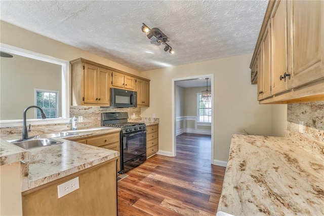 kitchen with black appliances, sink, dark hardwood / wood-style floors, and a textured ceiling