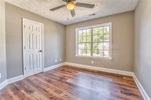 spare room with ceiling fan, dark wood-type flooring, and a textured ceiling