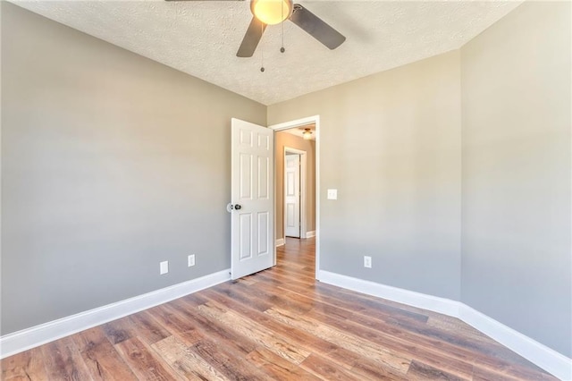 empty room with ceiling fan, a textured ceiling, and hardwood / wood-style floors