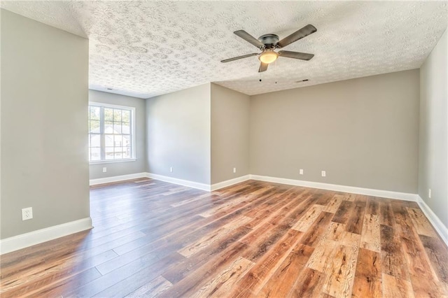 empty room featuring wood-type flooring, ceiling fan, and a textured ceiling