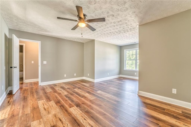 unfurnished room with ceiling fan, wood-type flooring, and a textured ceiling