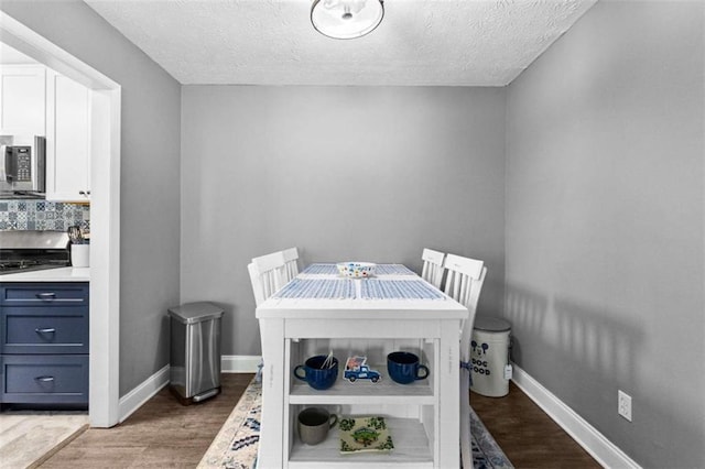 dining room featuring hardwood / wood-style flooring and a textured ceiling