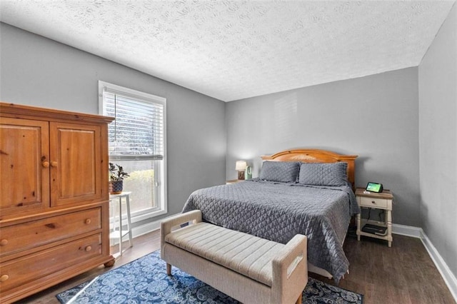 bedroom with dark hardwood / wood-style floors and a textured ceiling