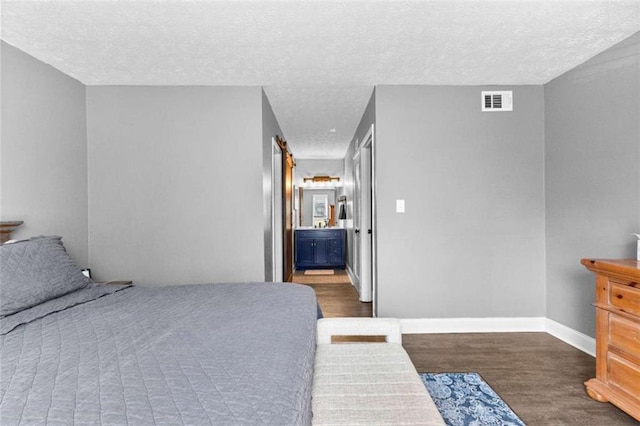 bedroom with a textured ceiling and dark hardwood / wood-style floors