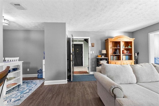 living room with dark hardwood / wood-style flooring and a textured ceiling