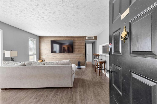 living room with dark hardwood / wood-style floors and a textured ceiling